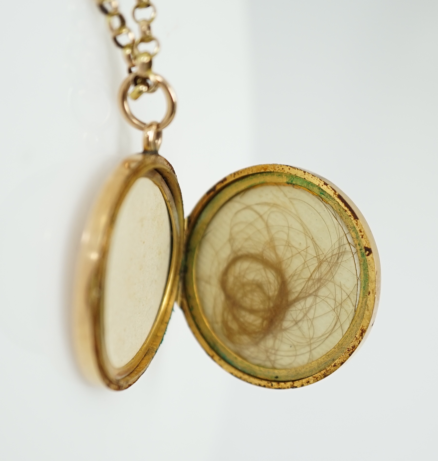 A George V engraved 9ct gold circular locket, diameter 25mm, on a 9ct chain, 45cm